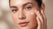 Woman pressing a dot of cream onto her cheek
