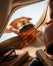 Hand holding an amber glass jar of cream
